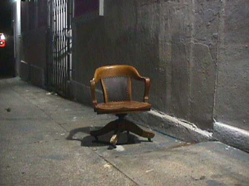 Photo Phloor: a chair alone on a night sidewalk.